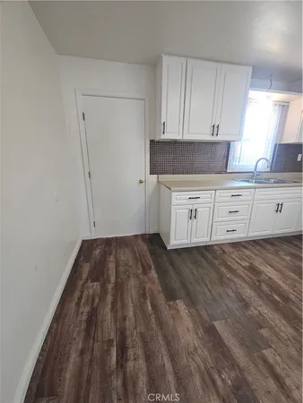 a kitchen with granite countertop white cabinets and white appliances