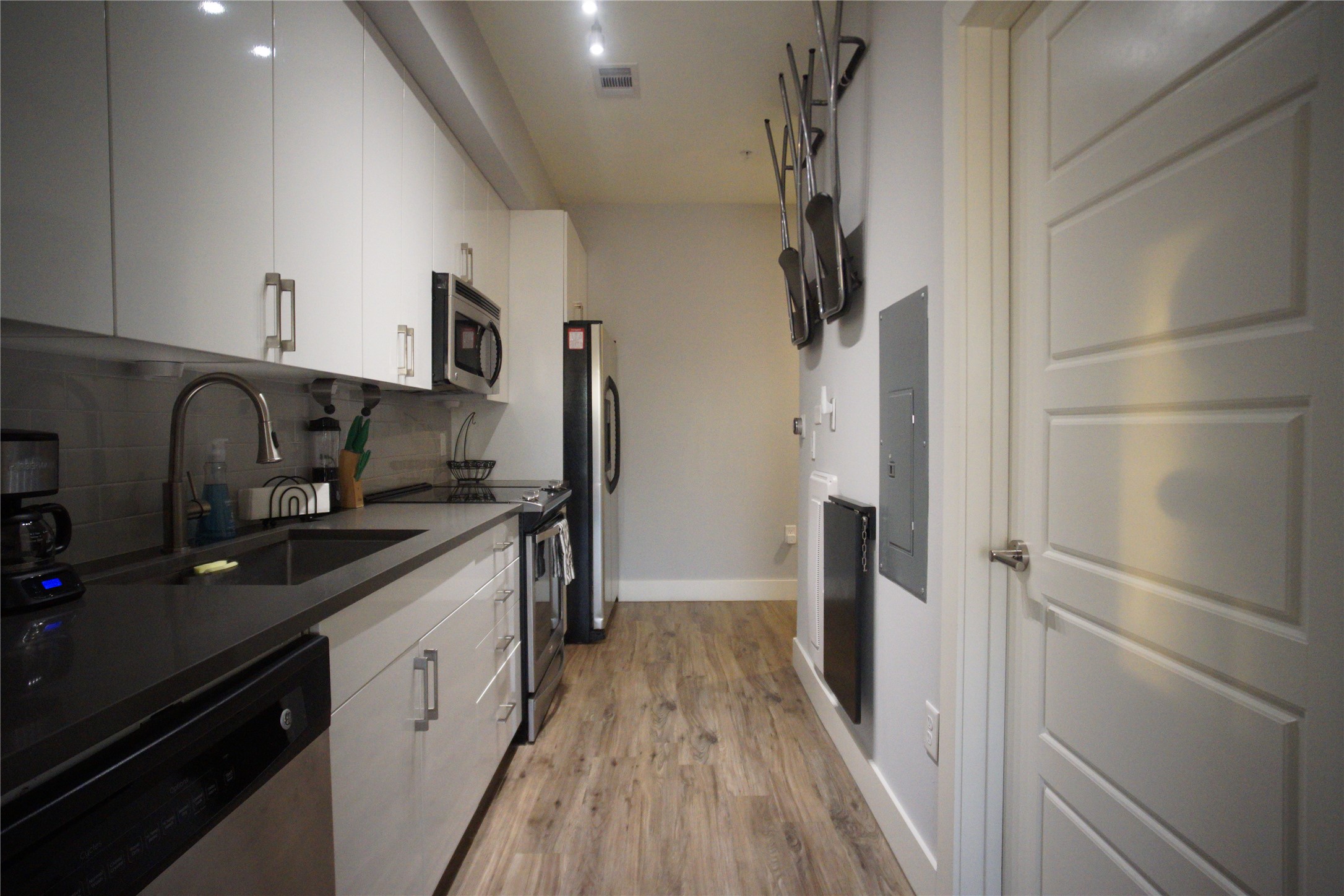 Efficient galley kitchen with modern finishes and convenient access to the full bathroom.