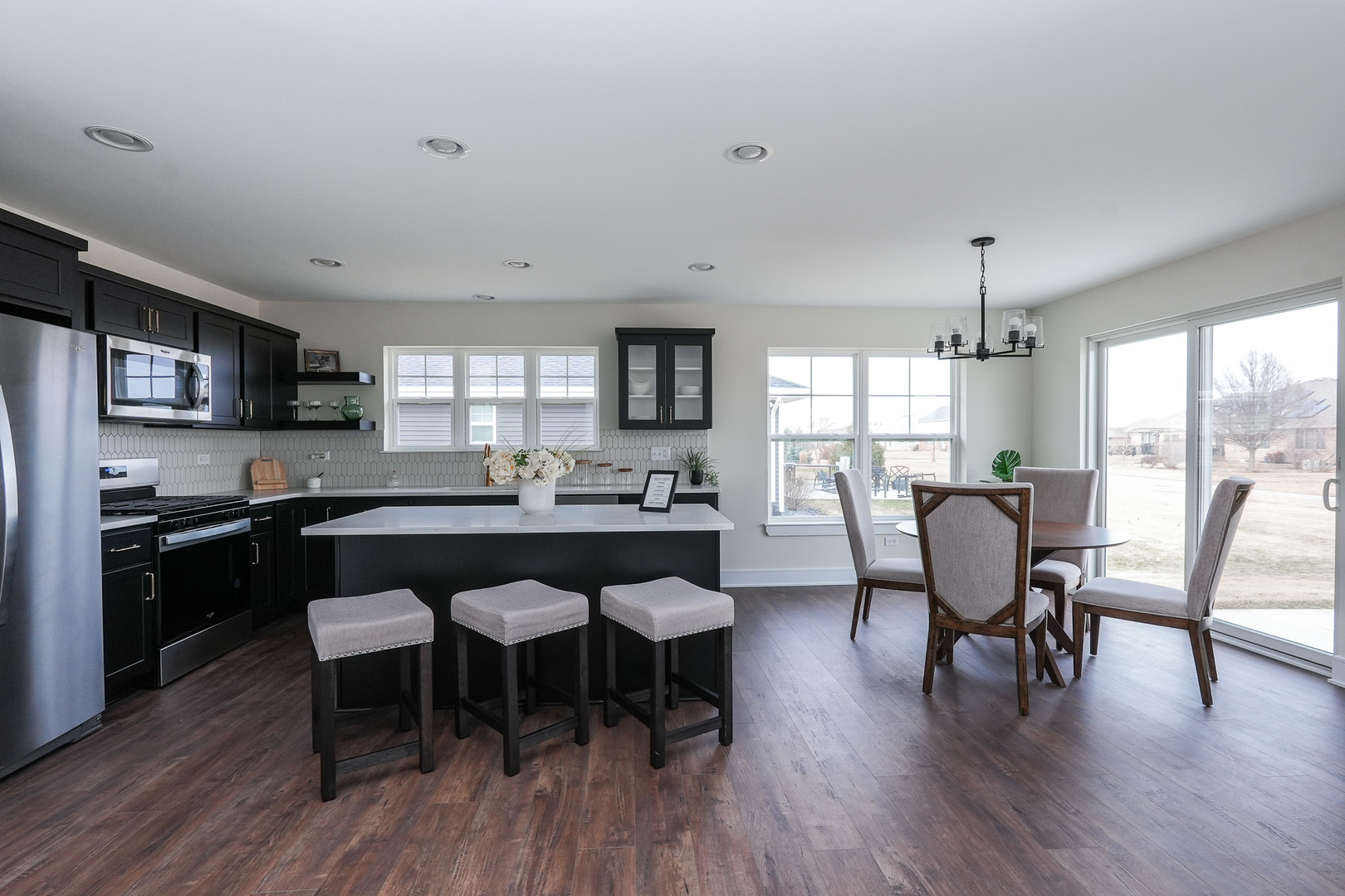 1009 Spring Street Manteno, IL 60950 - Photo 16 of 36 a kitchen with stainless steel appliances granite countertop a dining table chairs refrigerator sink and cabinets
