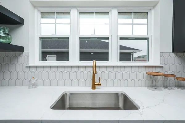 a living room with stainless steel appliances granite countertop furniture wooden floor and a kitchen view