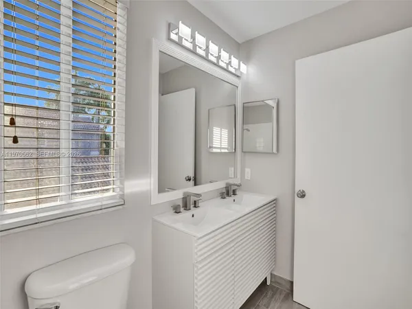 a bathroom with a sink a toilet and a mirror