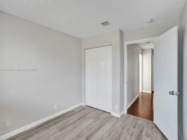 a view of an empty room with wooden floor