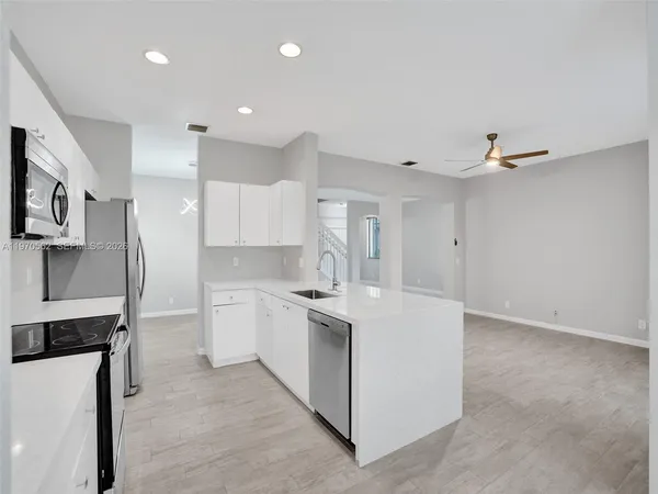 a large white kitchen with cabinets and stainless steel appliances