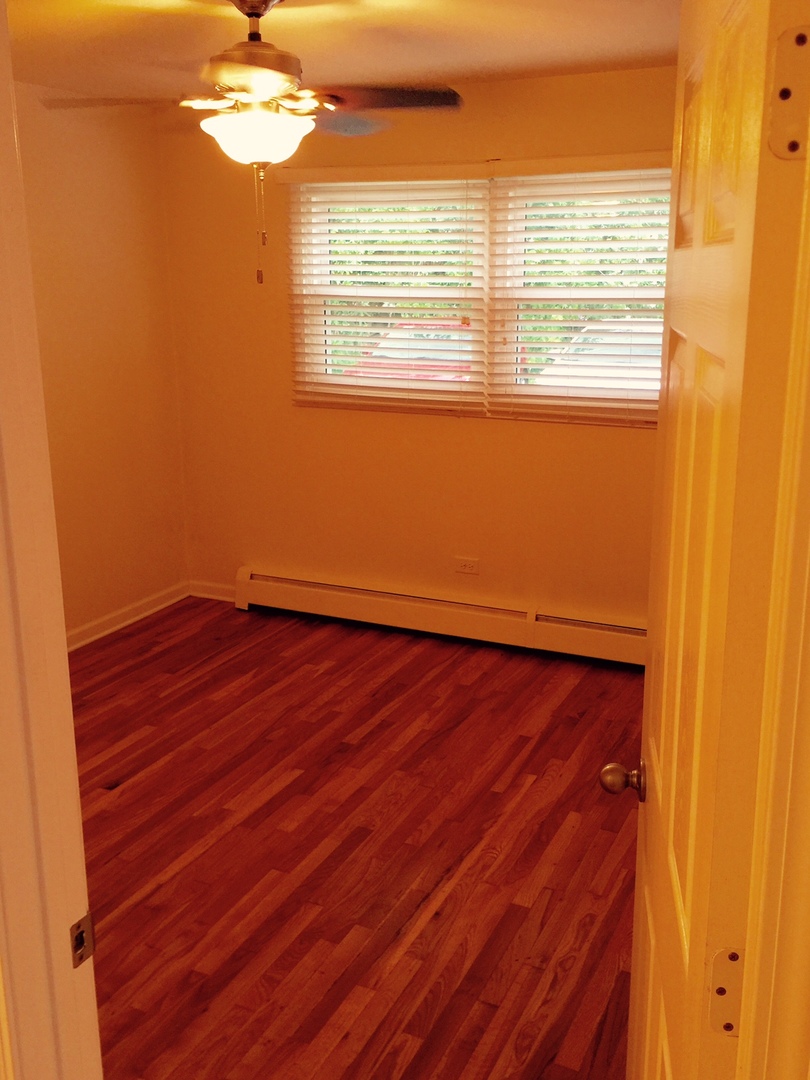 2290 182nd Place Lansing, IL 60438 - Photo 7 of 16 a view of a room with wooden floor and fan