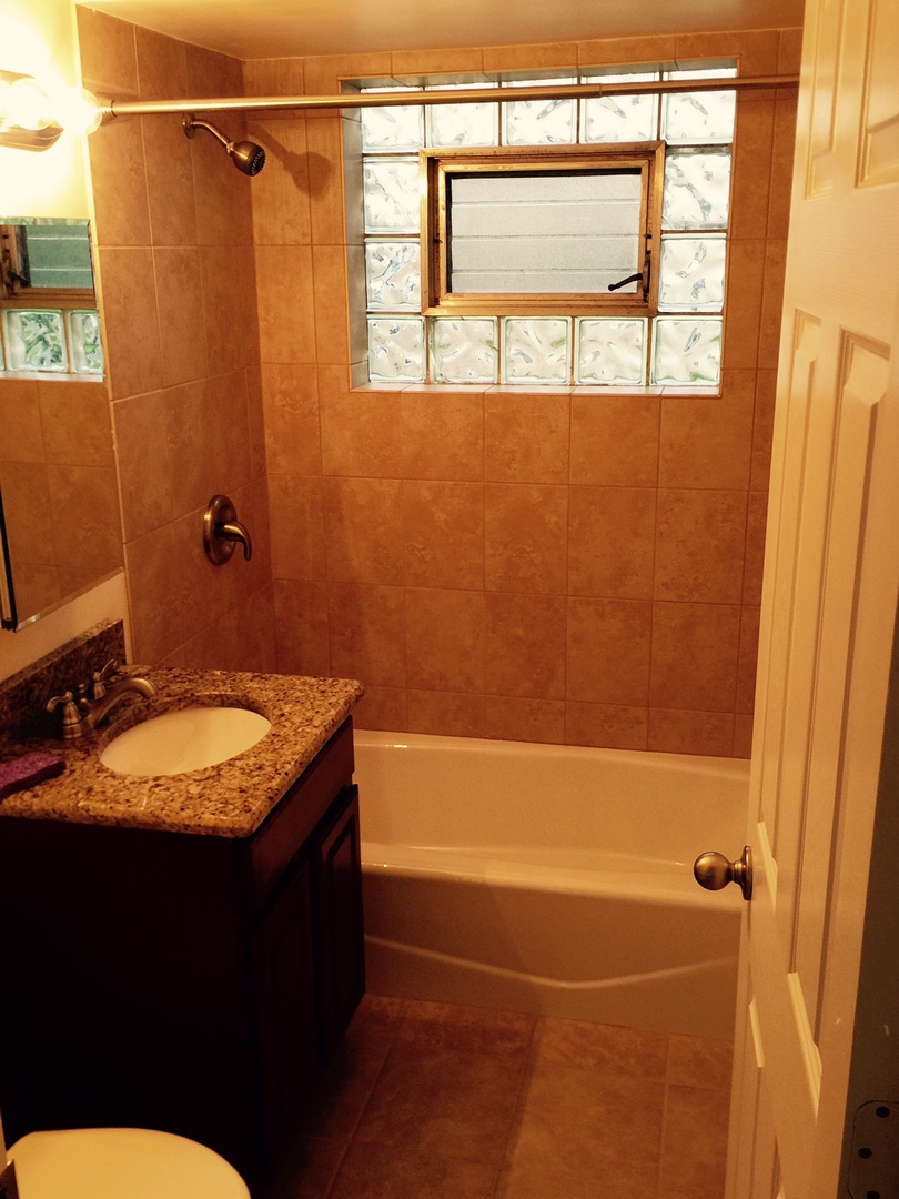 2290 182nd Place Lansing, IL 60438 - Photo 8 of 16 a bathroom with a granite countertop sink a toilet and shower