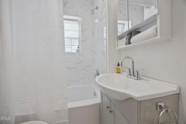 a bedroom with a bed and a potted plant on dresser