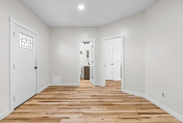 a view of a bedroom with wooden floor and bathroom