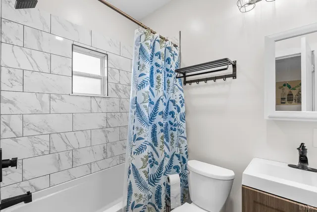 a bathroom with a shower curtain and a toilet
