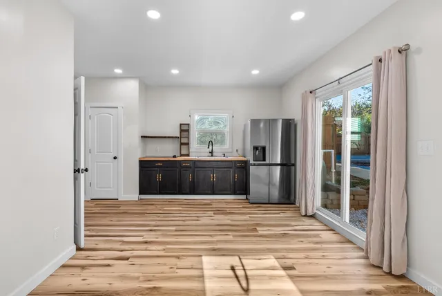 a kitchen with kitchen island a counter top space and stainless steel appliances wooden floor