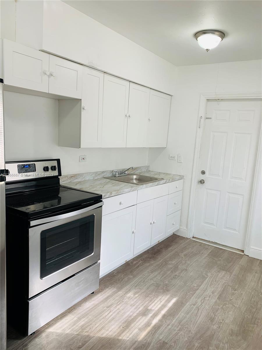 738 Northeast 86th Street, Unit 8 Miami, FL 33138 - Photo 5 of 10 a kitchen with a stove oven and white cabinets