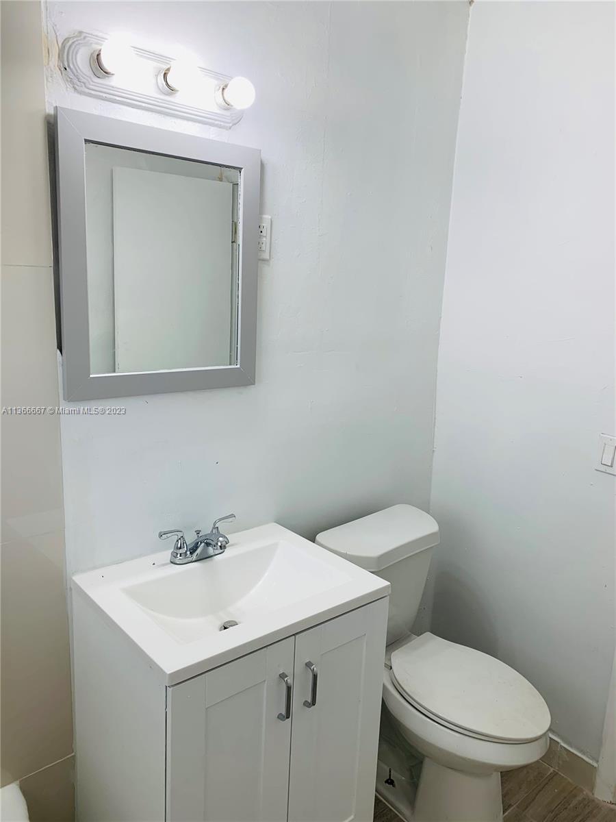 738 Northeast 86th Street, Unit 8 Miami, FL 33138 - Photo 7 of 10 a bathroom with a toilet sink and mirror