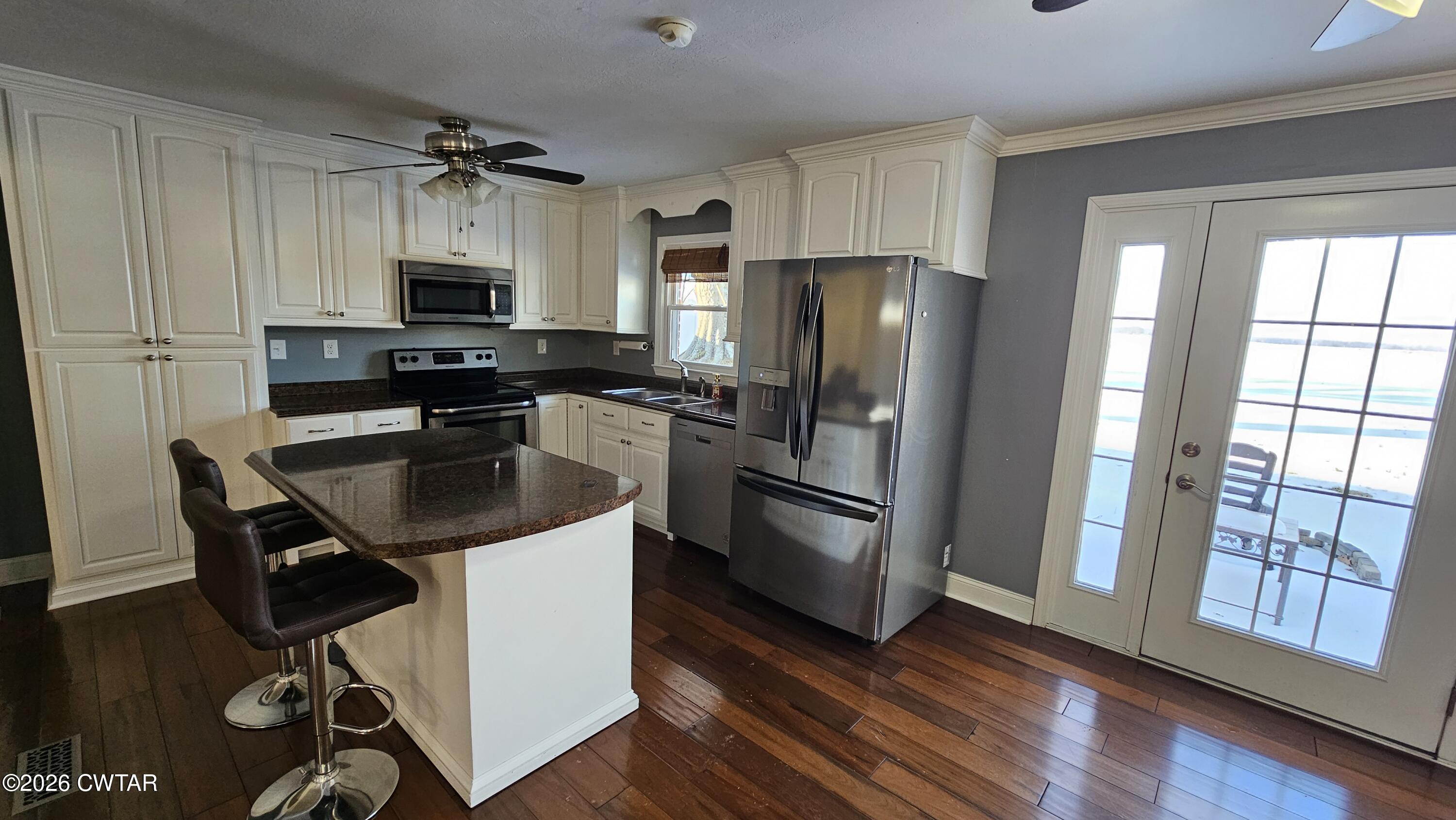 516 West Knox Street Rutherford, TN 38369 - Photo 5 of 19 a kitchen with stainless steel appliances a sink a stove a refrigerator cabinets and wooden floor