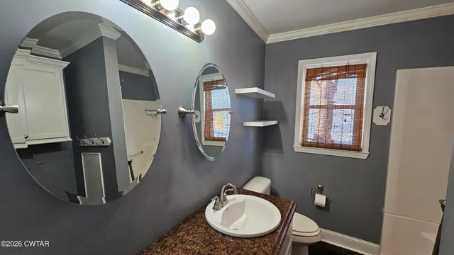 a bathroom with a granite countertop toilet a sink and mirror