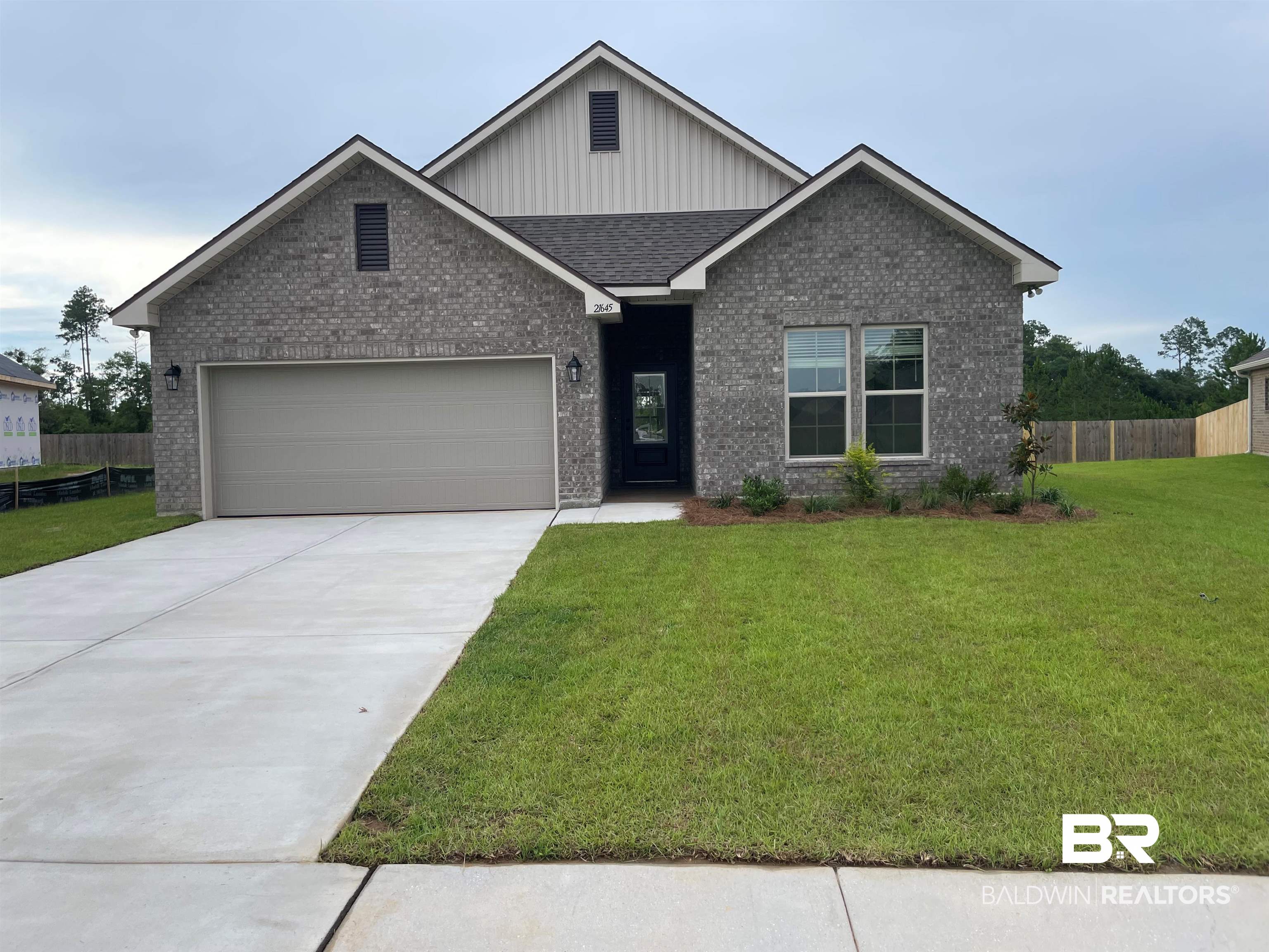 21645 Pine Knot Way Foley, AL 36535 - Photo 1 of 3 Contemporary residence featuring a dark gray brick facade with light gray vertical siding accents