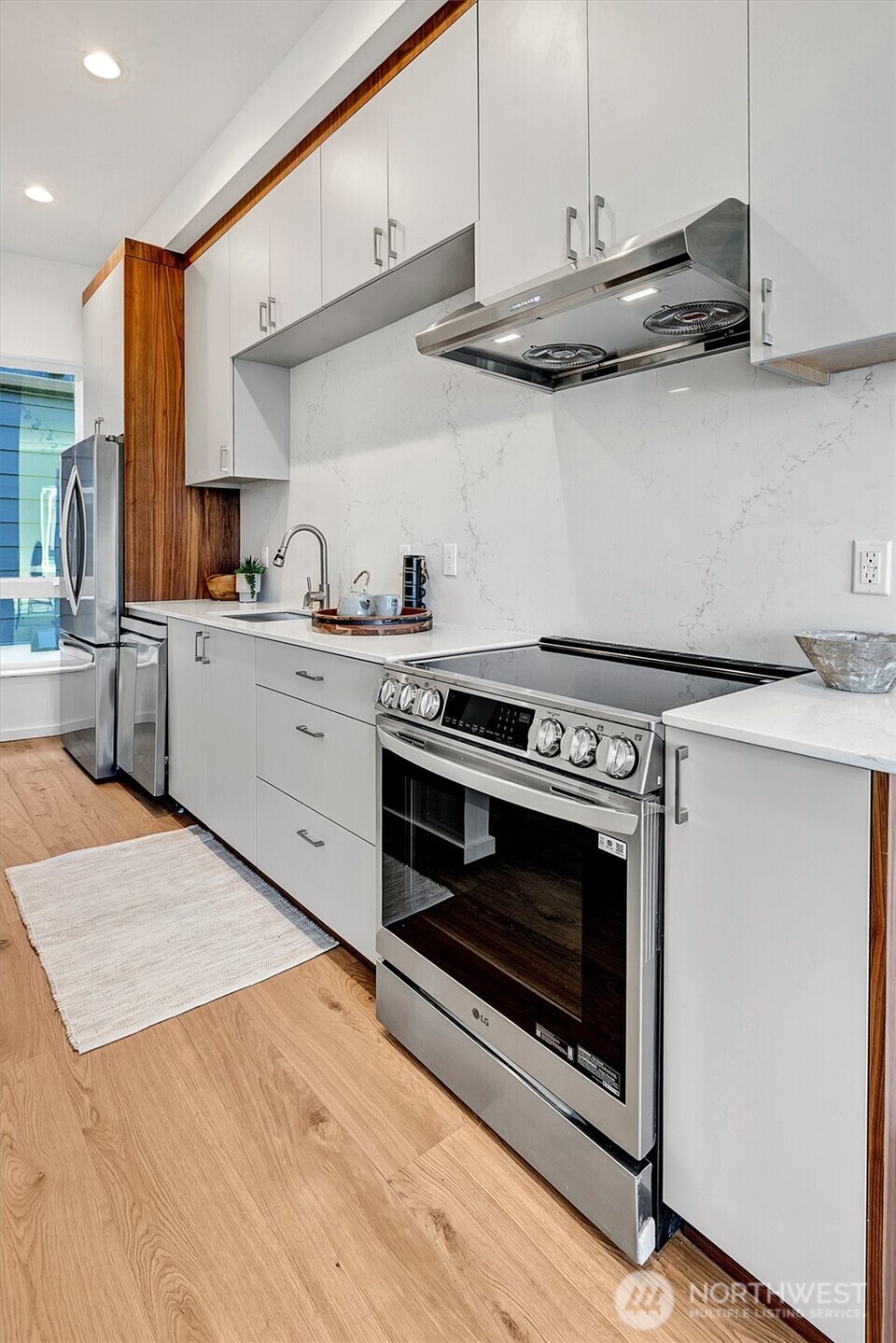 1227 East Roy Street Seattle, WA 98102 - Photo 16 of 35 a kitchen with stainless steel appliances granite countertop a stove and white cabinets