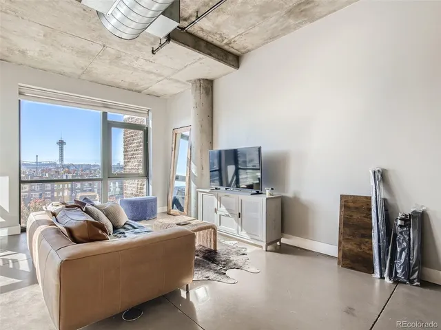 a living room with furniture a flat screen tv and a large window