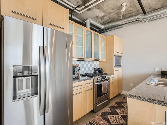 a kitchen with stainless steel appliances granite countertop a refrigerator and a stove
