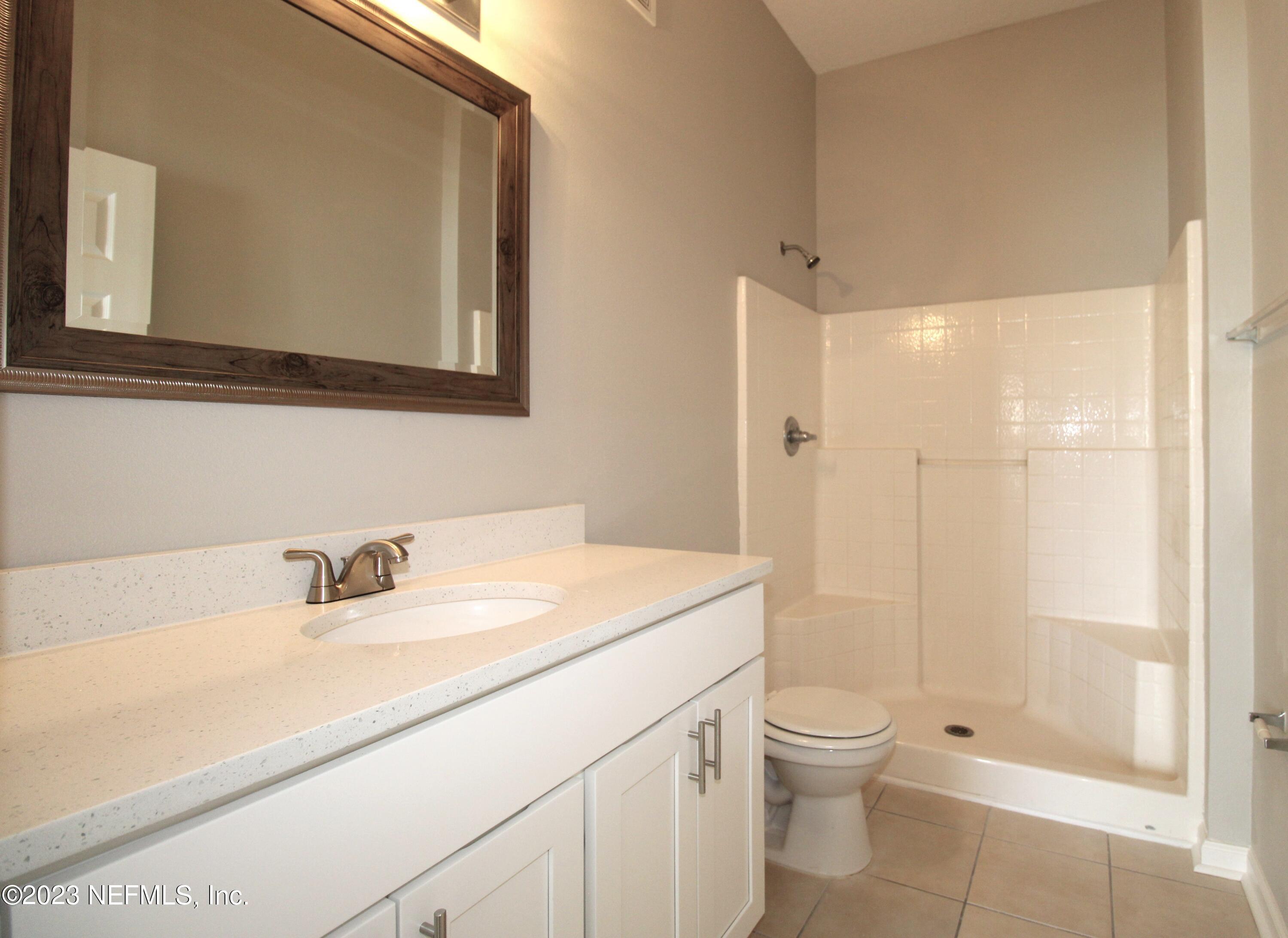 416 Golden Lake Loop St. Augustine, FL 32084 - Photo 12 of 22 a bathroom with a granite countertop sink a toilet and a mirror