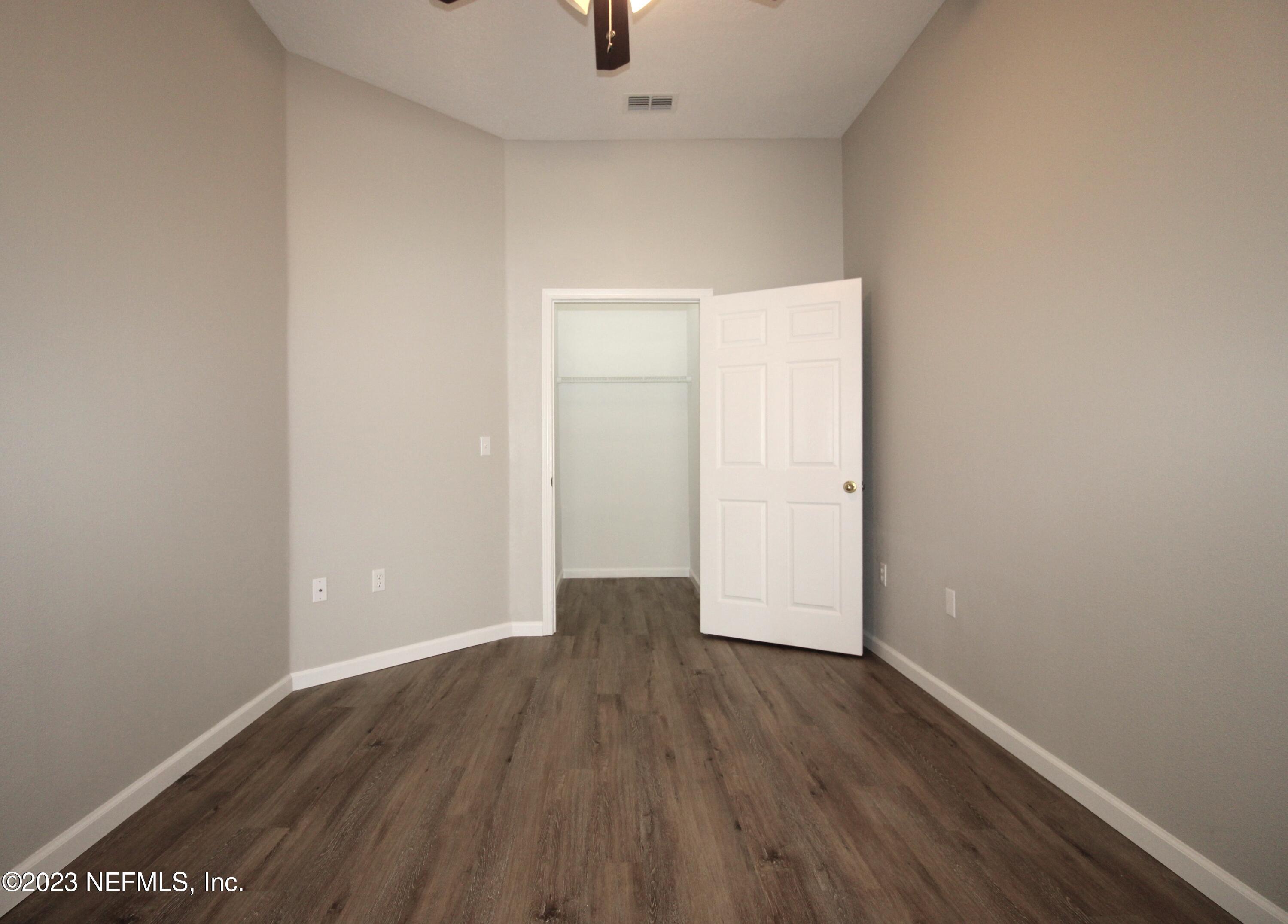 416 Golden Lake Loop St. Augustine, FL 32084 - Photo 13 of 22 an empty room with wooden floor and windows