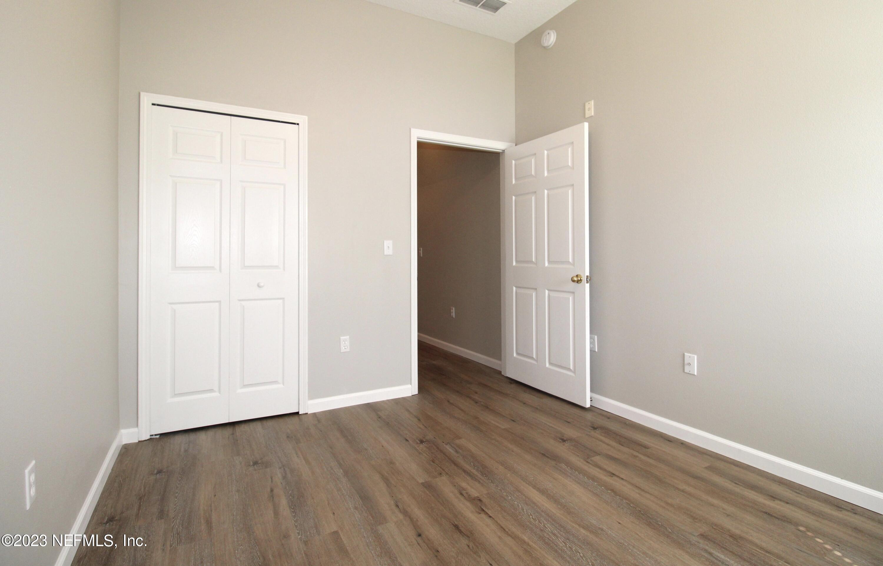 416 Golden Lake Loop St. Augustine, FL 32084 - Photo 14 of 22 an empty room with wooden floor and closet area