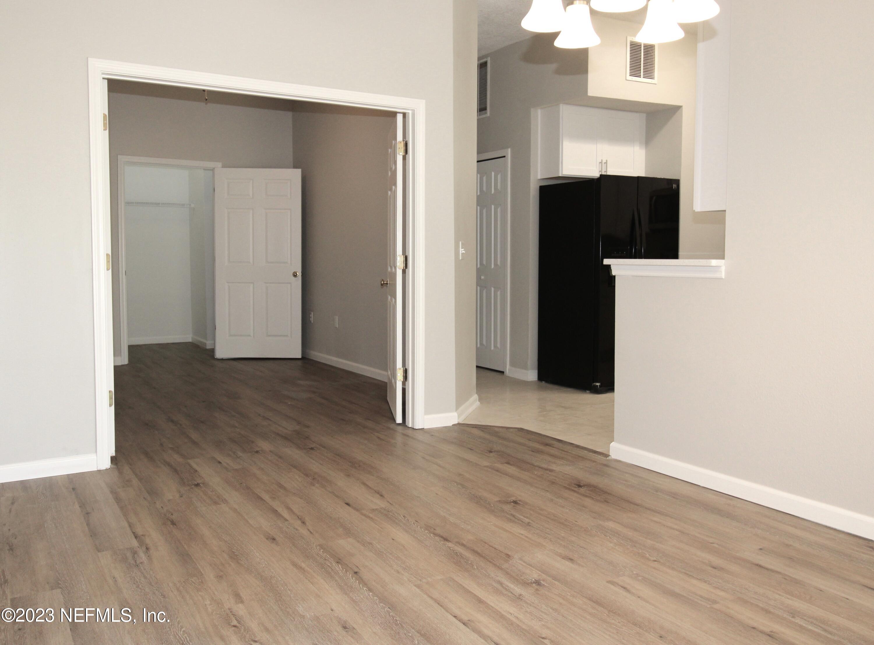 416 Golden Lake Loop St. Augustine, FL 32084 - Photo 7 of 22 an empty room with wooden floor and staircase