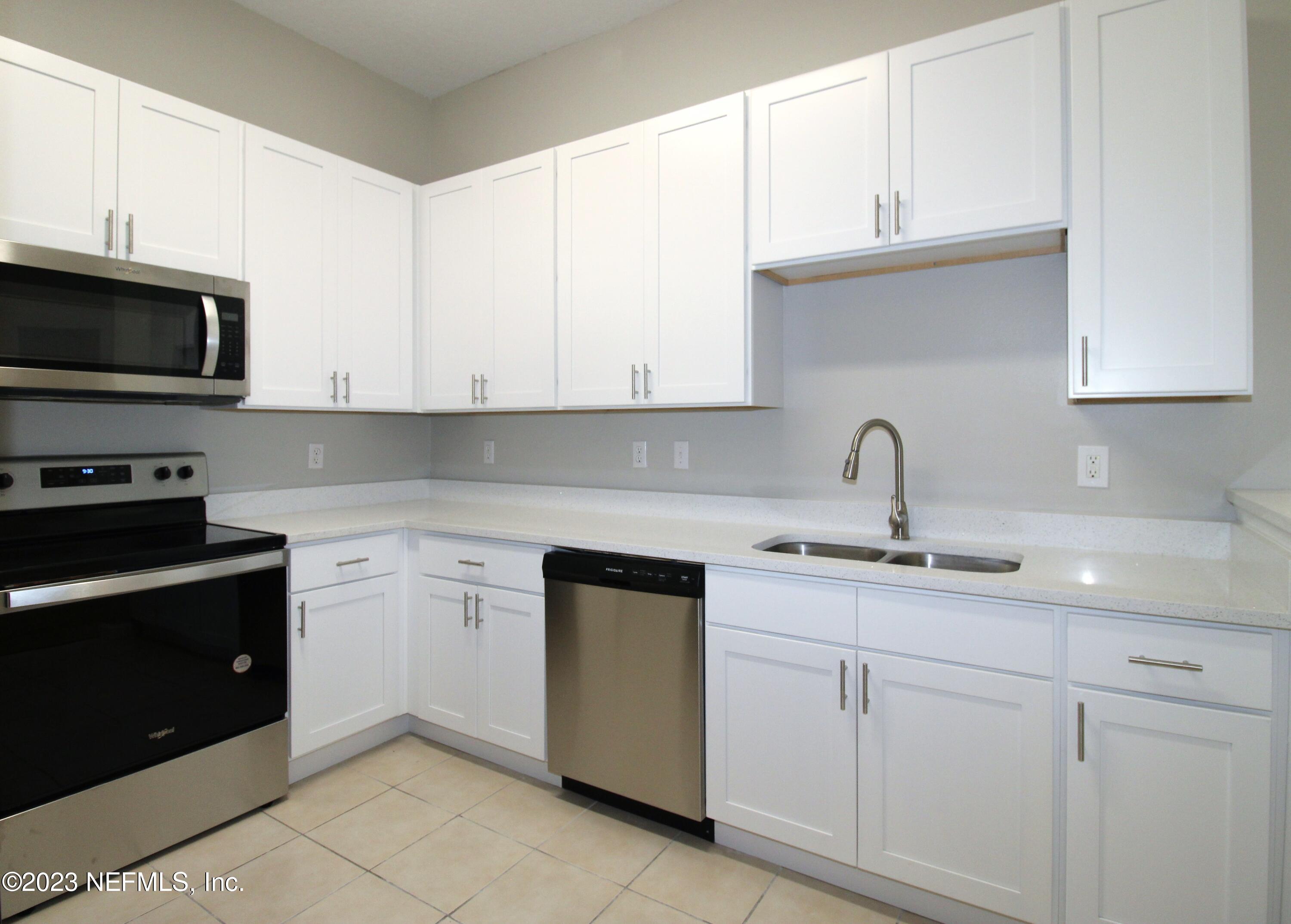 416 Golden Lake Loop St. Augustine, FL 32084 - Photo 8 of 22 a kitchen with white cabinets and a stove top oven