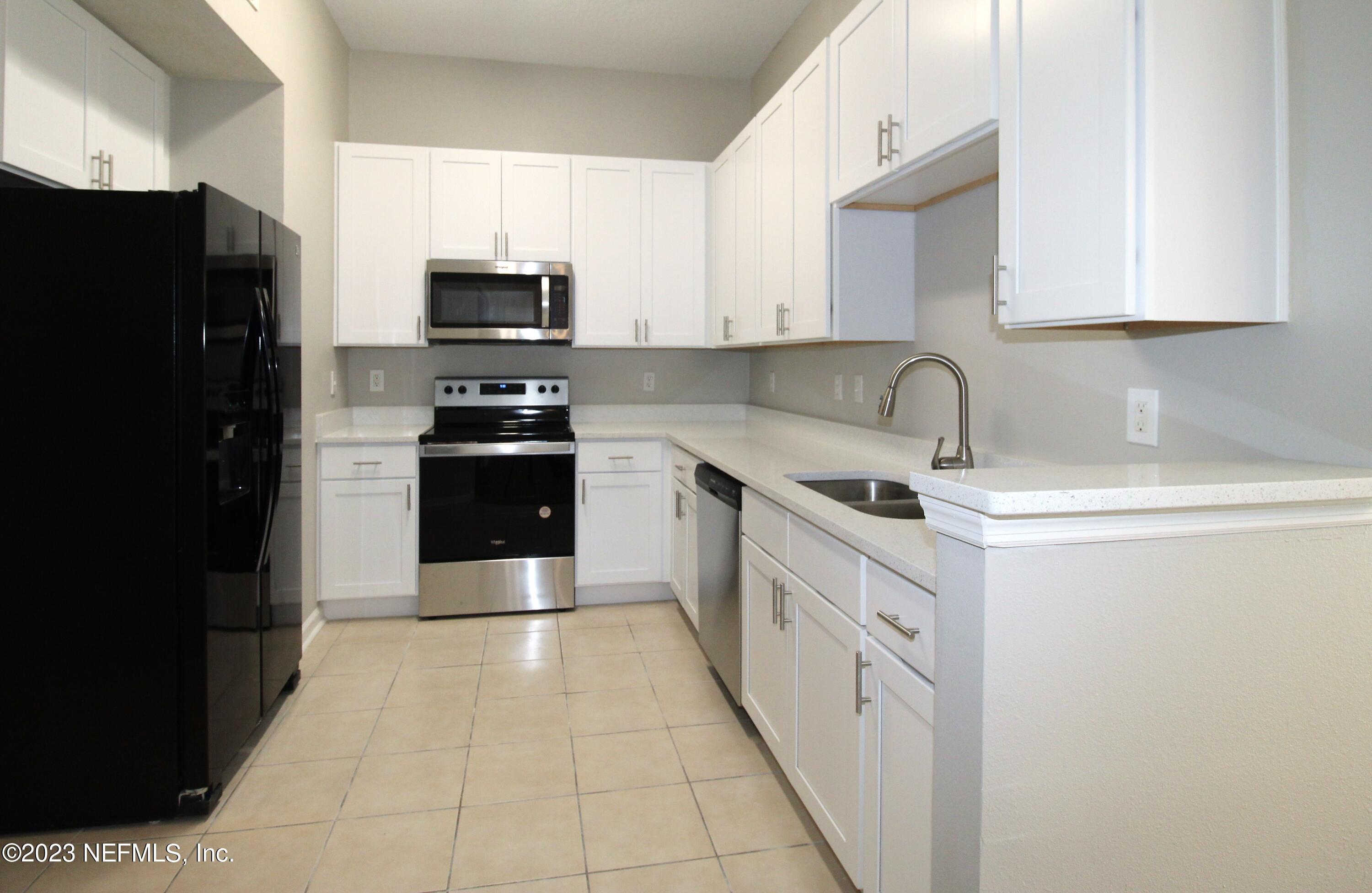 416 Golden Lake Loop St. Augustine, FL 32084 - Photo 10 of 22 a kitchen with granite countertop a refrigerator and a sink