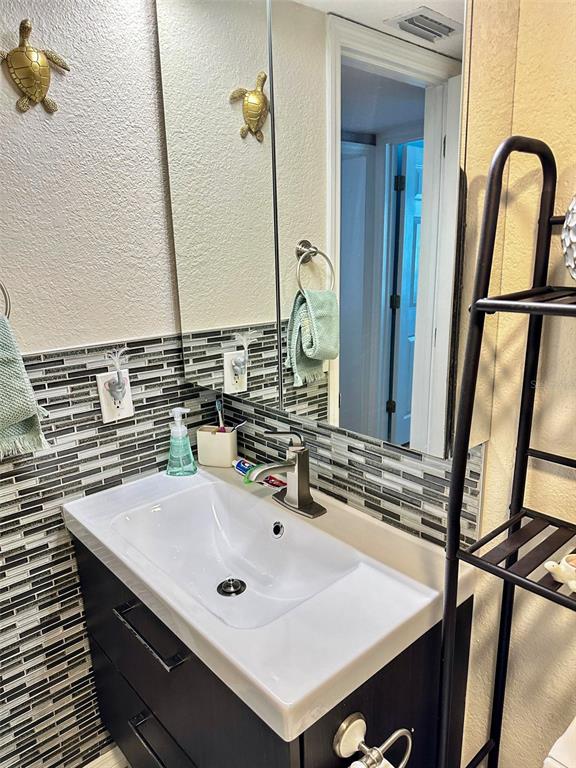 8911 Blind Pass Road, Unit 220 St. Pete Beach, FL 33706 - Photo 37 of 67 a bathroom with a sink and a mirror