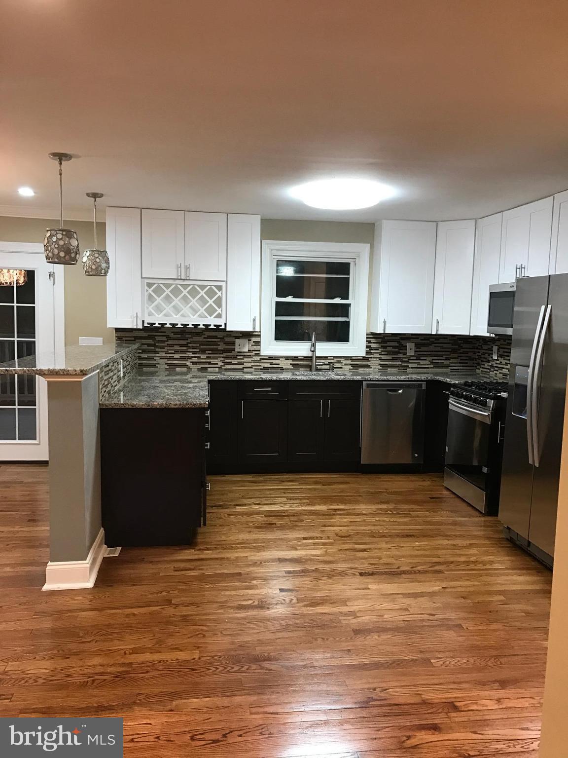 a kitchen with stainless steel appliances granite countertop a stove top oven a sink dishwasher a refrigerator and a microwave