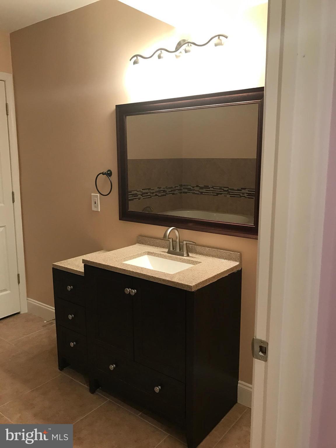 6710 Fox Meadow Road Baltimore, MD 21207 - Photo 17 of 24 a bathroom with a sink and a mirror