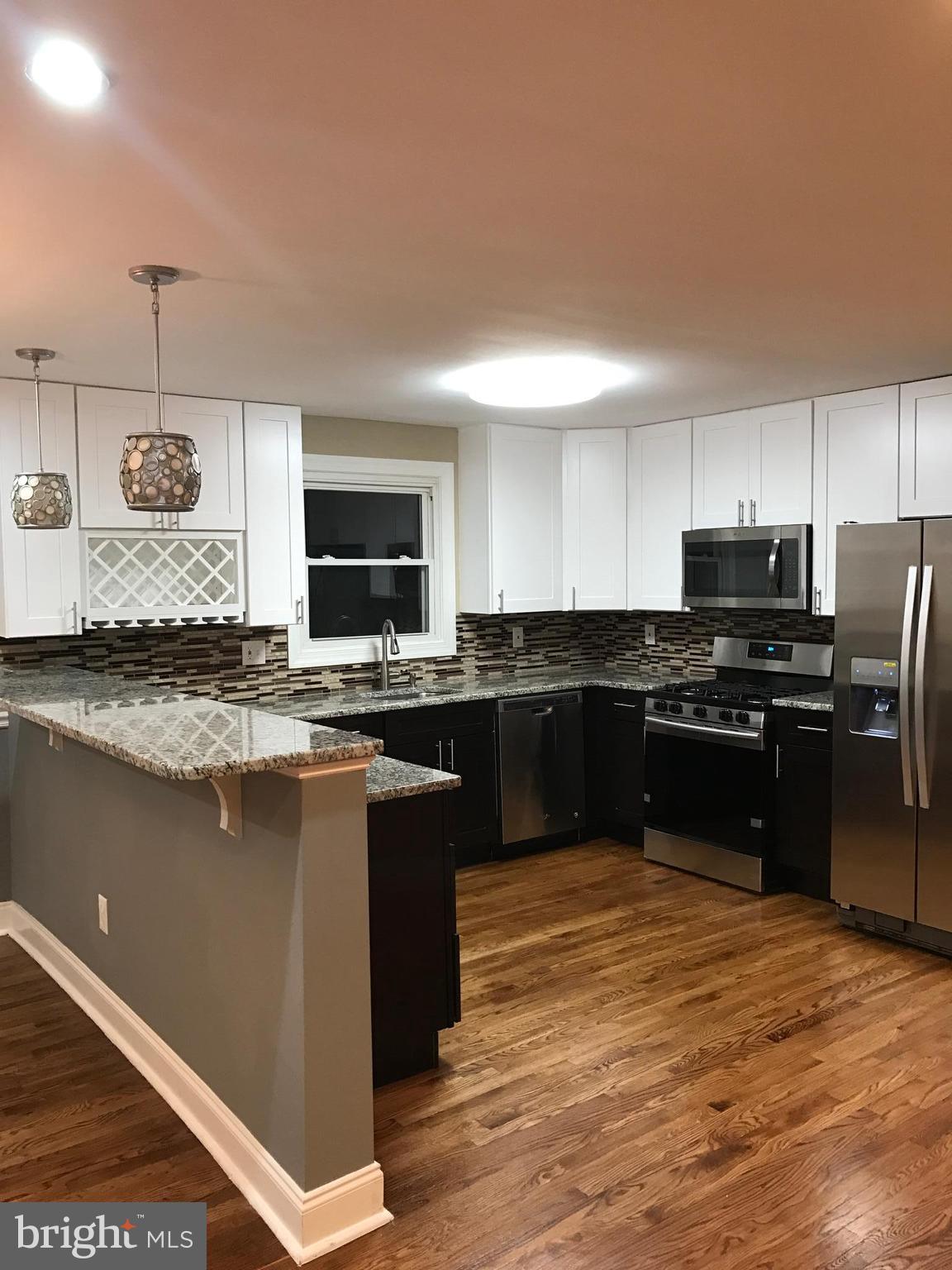 6710 Fox Meadow Road Baltimore, MD 21207 - Photo 23 of 24 a kitchen with granite countertop stainless steel appliances and wooden cabinets