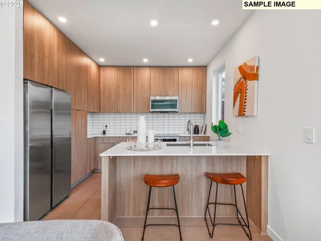 a kitchen with stainless steel appliances granite countertop a stove a sink and a refrigerator