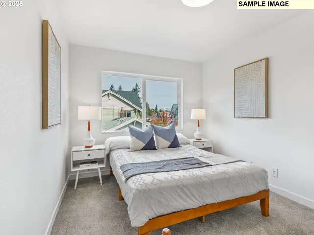 a bedroom with a bed and a lamp on dresser