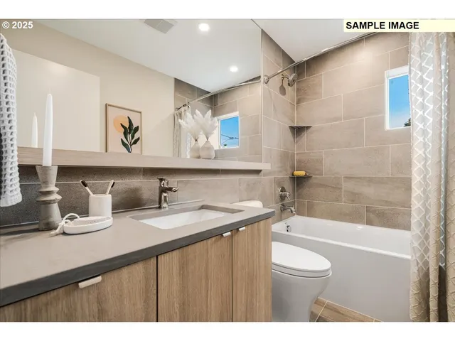 a bathroom with a granite countertop sink a toilet and bathtub