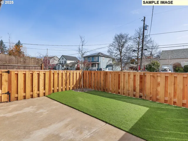 a view of a backyard with wooden fence