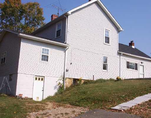 Exterior Front. Fully sided with a pale gray vinyl siding for little maintainance.