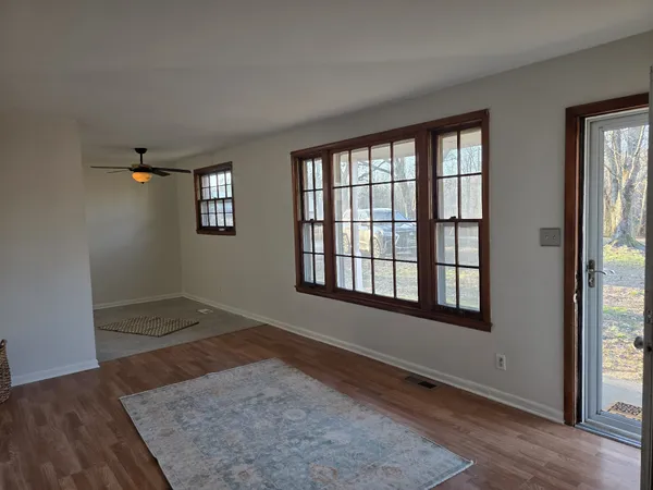 an empty room with wooden floor and windows