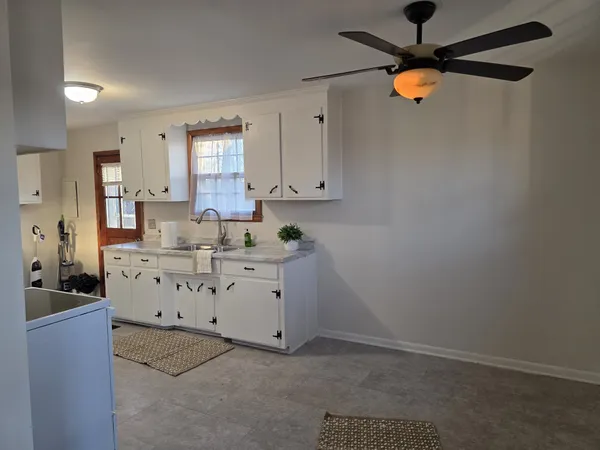 a kitchen with stainless steel appliances white cabinets and a wooden floor