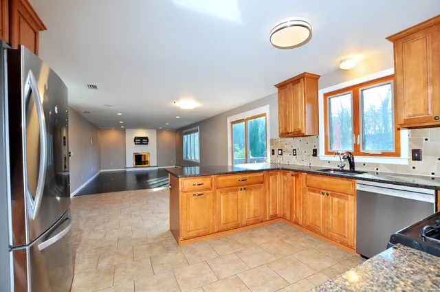 a large kitchen with kitchen island a sink stainless steel appliances and a counter space