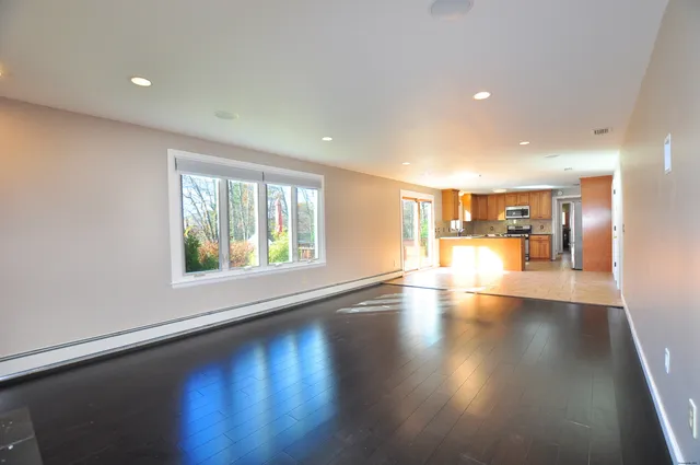 a view of a living room and dining room with wooden floor