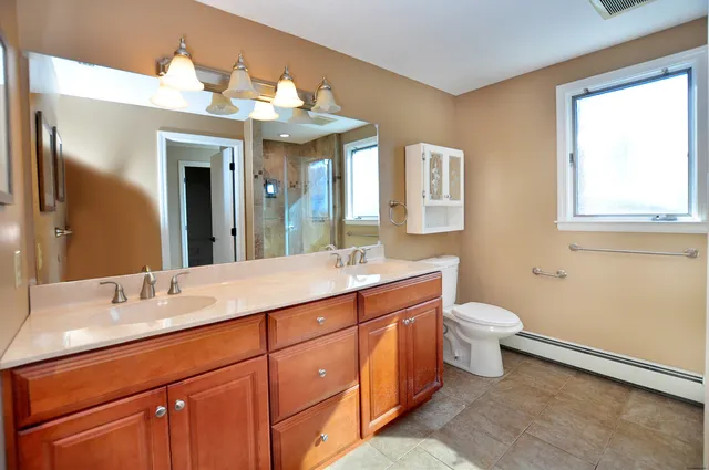 a bathroom with a sink mirror and a toilet