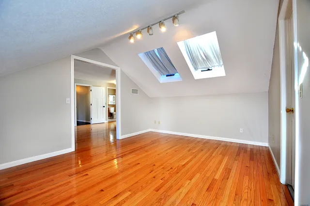 a view of empty room with wooden floor