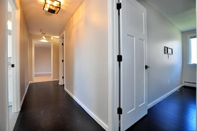 a view of an empty room with wooden floor
