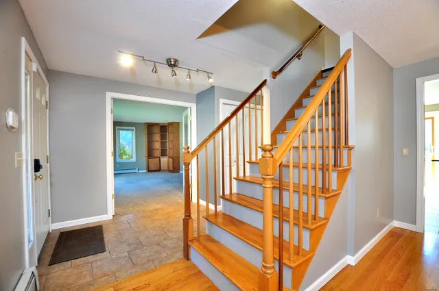 a view of entryway and hall with wooden floor