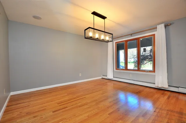 a view of an empty room with window chandelier fan