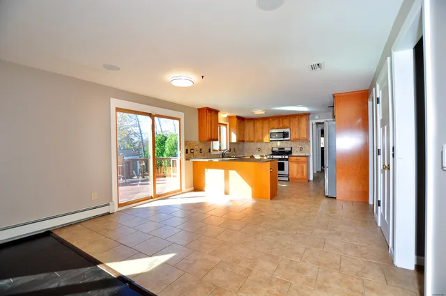 a open kitchen with stainless steel appliances granite countertop a refrigerator and a sink