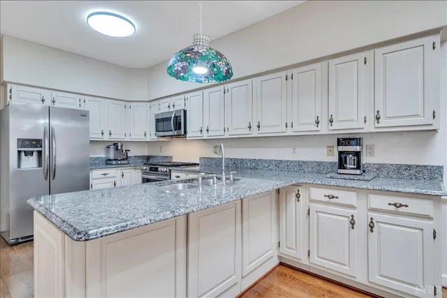 a kitchen with granite countertop a white cabinets and refrigerator