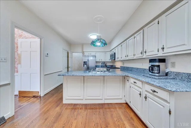 a kitchen with stainless steel appliances granite countertop a sink cabinets and wooden floor