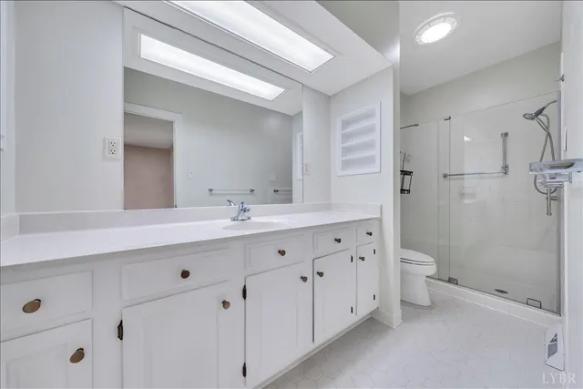 a bathroom with a double vanity sink toilet and shower