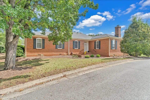 a view of a house with a backyard and a tree